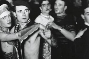 Image of four men dancing together in drag.